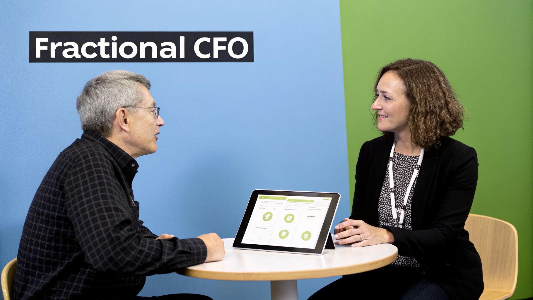 Two professionals discussing data on a tablet, with 'Fractional CFO' text in the background.