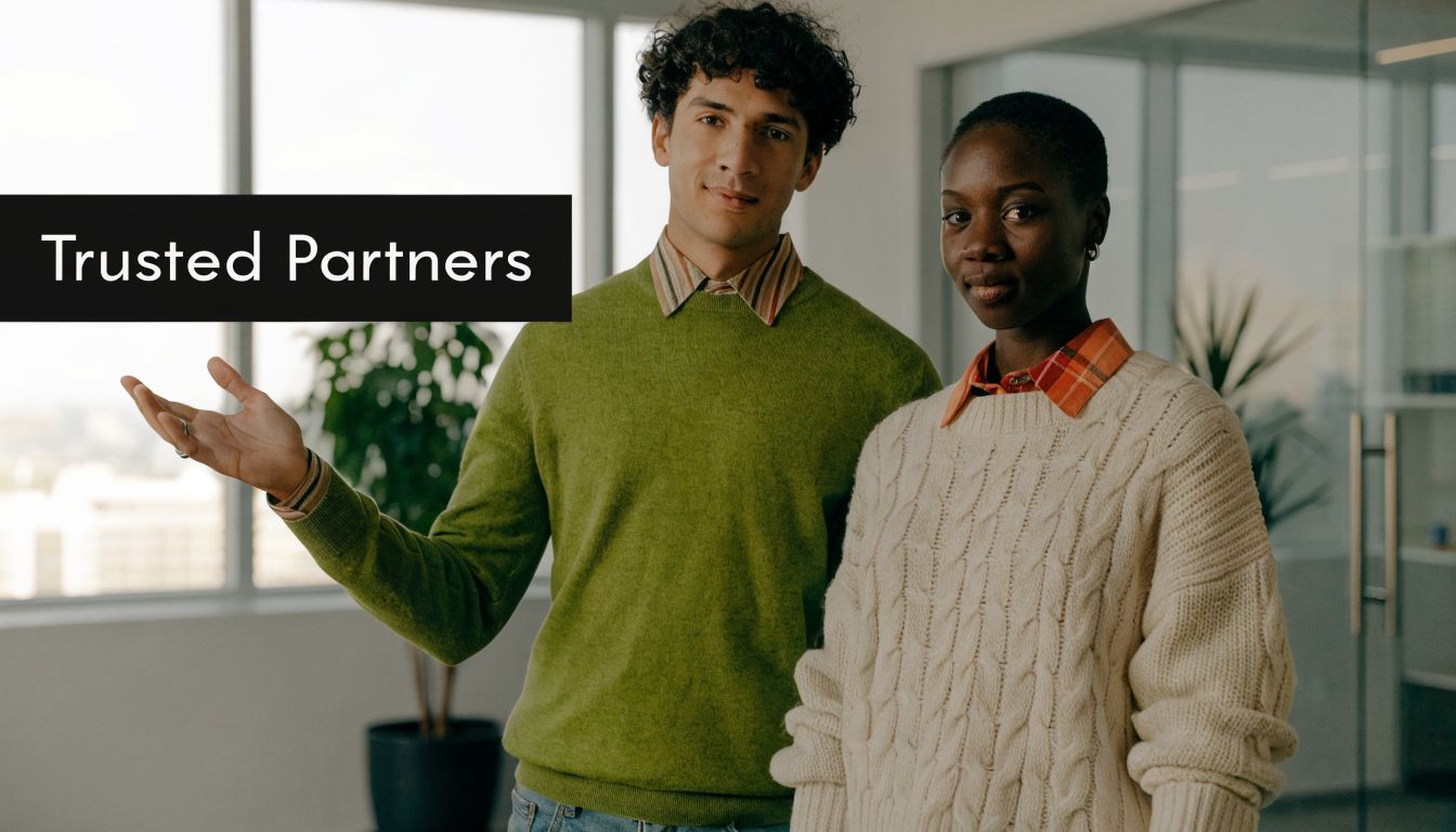 A professional man and woman standing together in an office setting, representing trusted business partners.