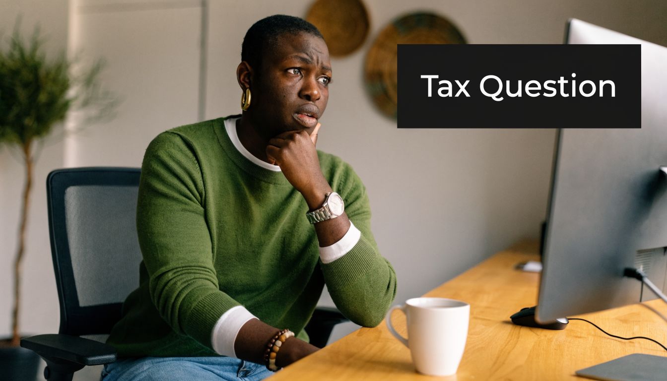 A concerned person sitting at a desk looking at a computer monitor during a tax consultation.